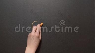 目标。一只左手在黑板上用橙色粉笔写下“目标”一词。概念粉笔画